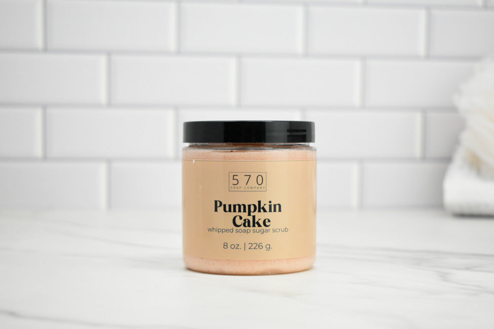 Jar of 570 whipped body scrub labeled 'Pumpkin Cake' on a white tiled background