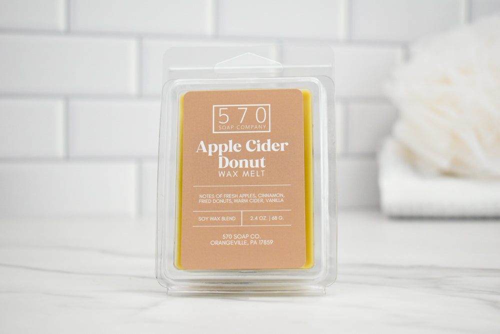 570 Apple Cider Donut wax melt packaging on a white surface with a tiled wall background