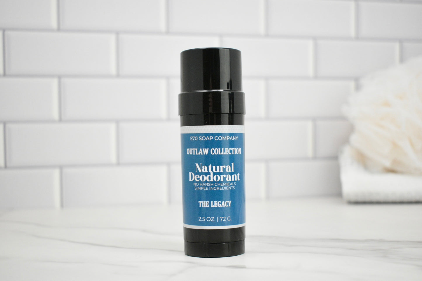Natural deodorant stick on a bathroom counter with a white tiled wall background