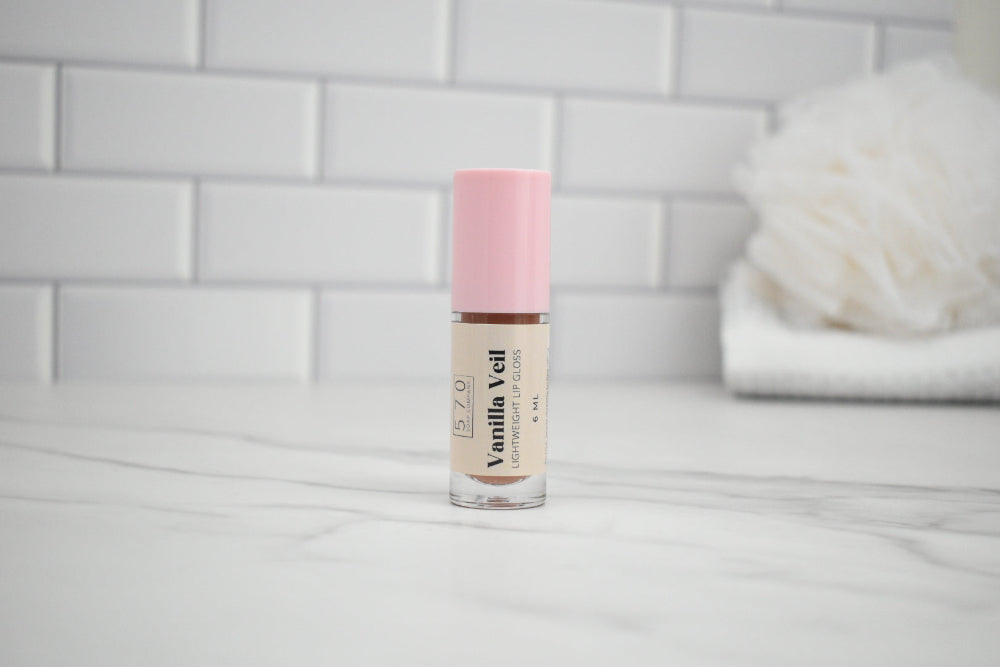 Cosmetic bottle with pink cap on a white surface