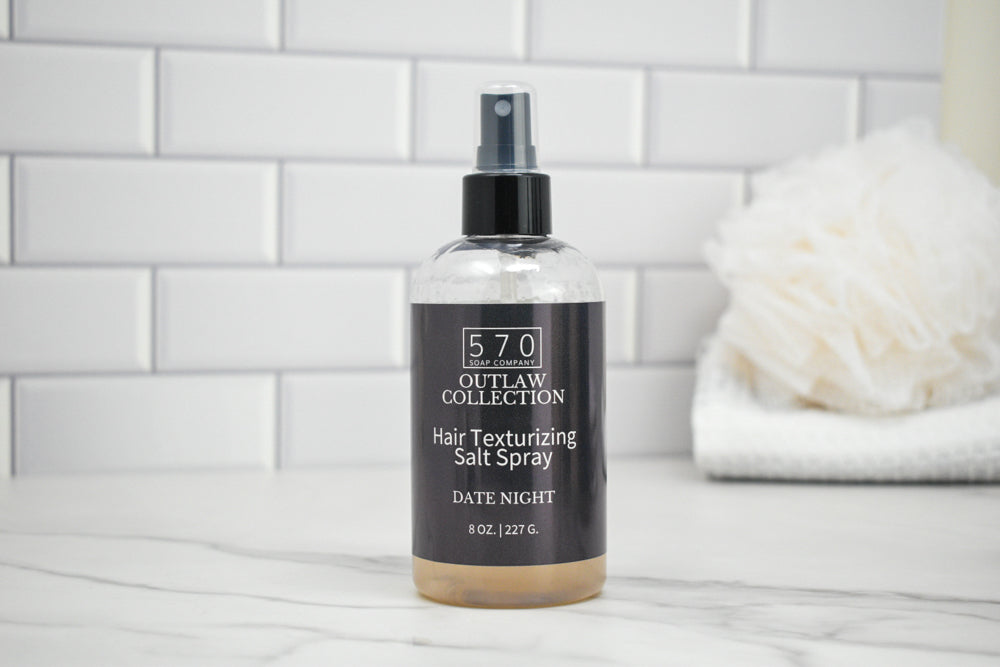 Bottle of 570 Outlaw Collection Hair Texturizing Salt Spray on a bathroom counter.