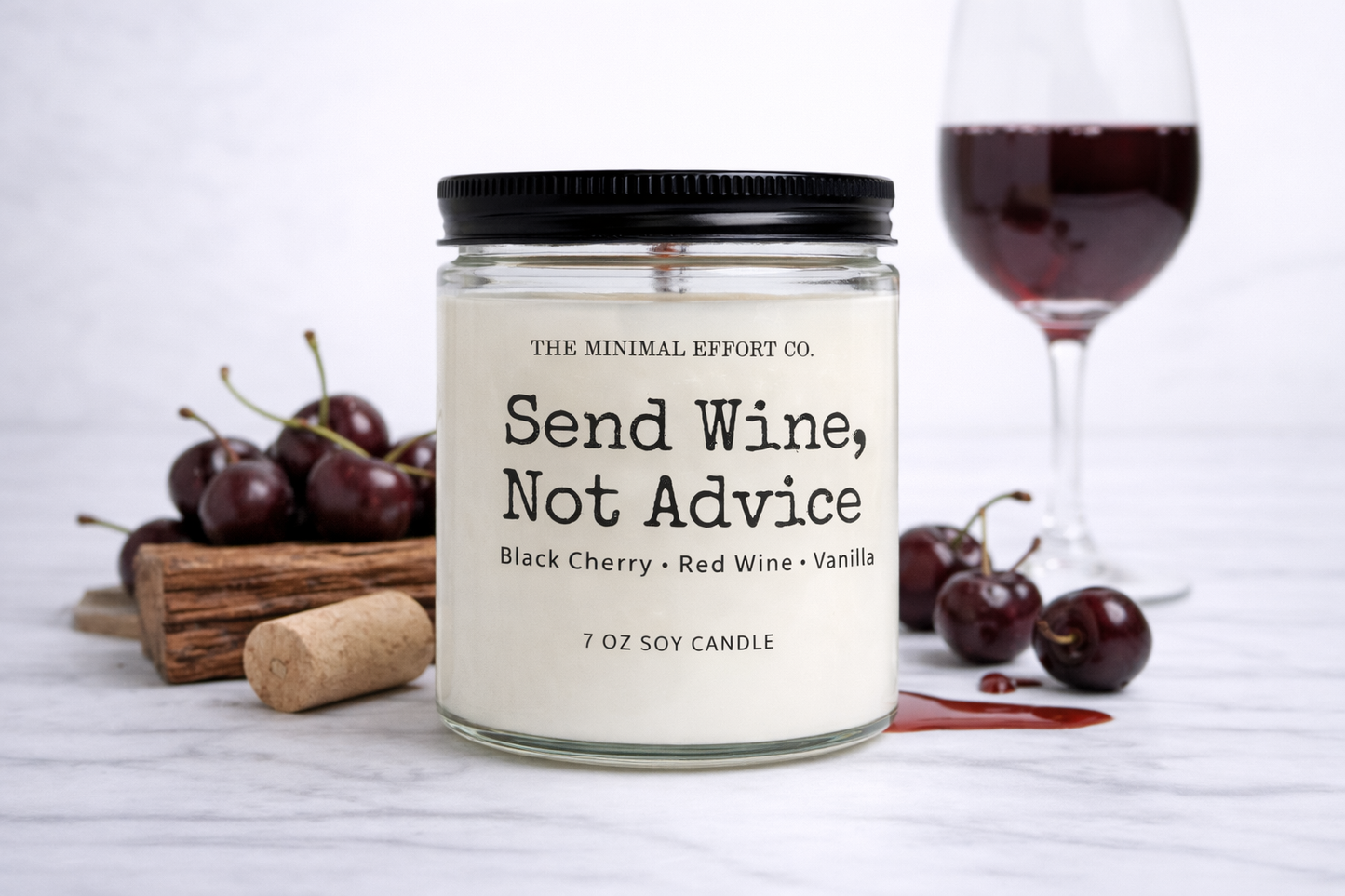 Candle labeled 'Send Wine, Not Advice' with wine glass and cherries on a white background