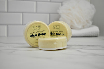 Two containers of 570 dish soap on a bathroom counter with a towel in the background.