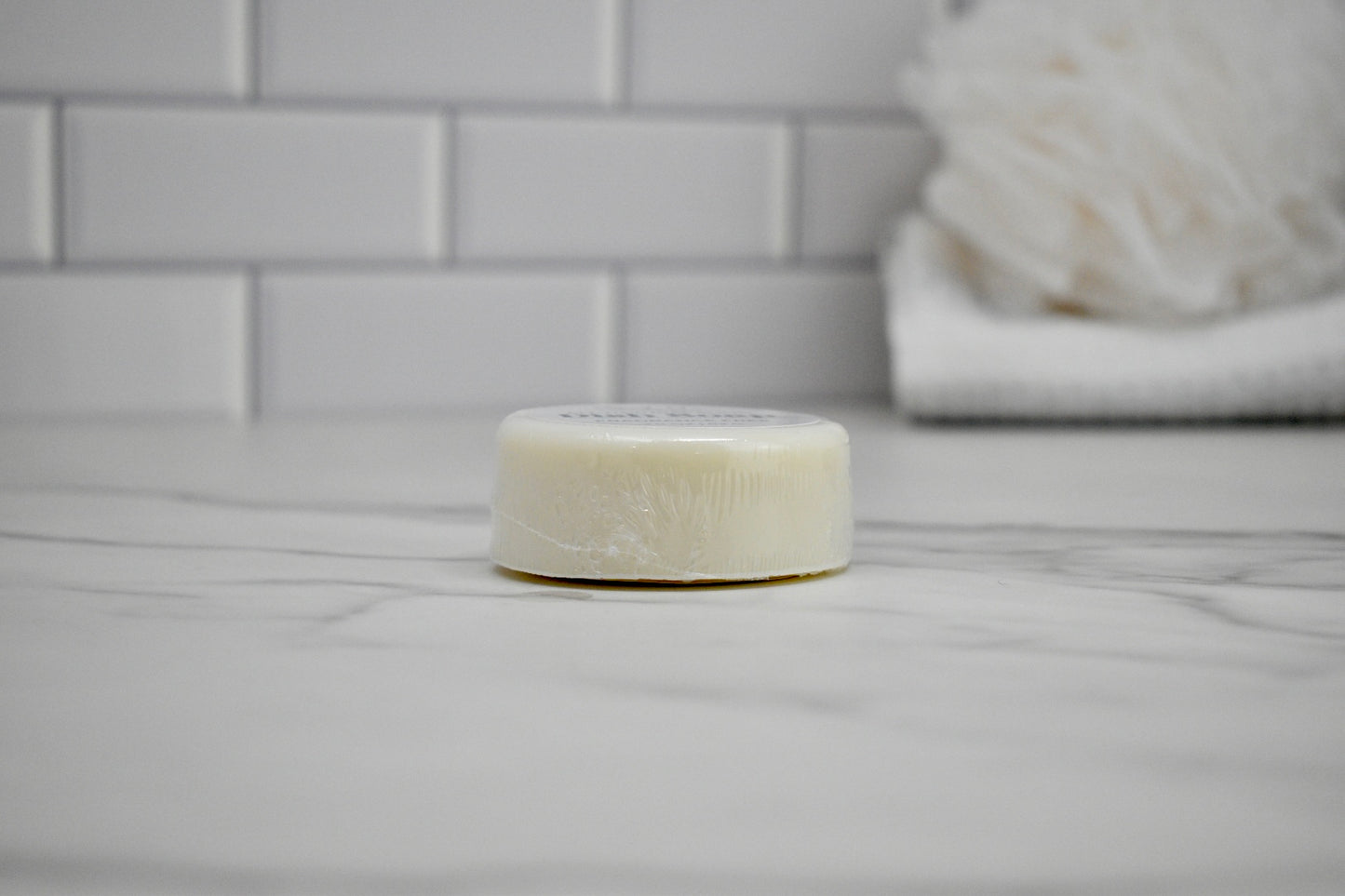 Bar of soap on a bathroom counter with tiled wall in the background