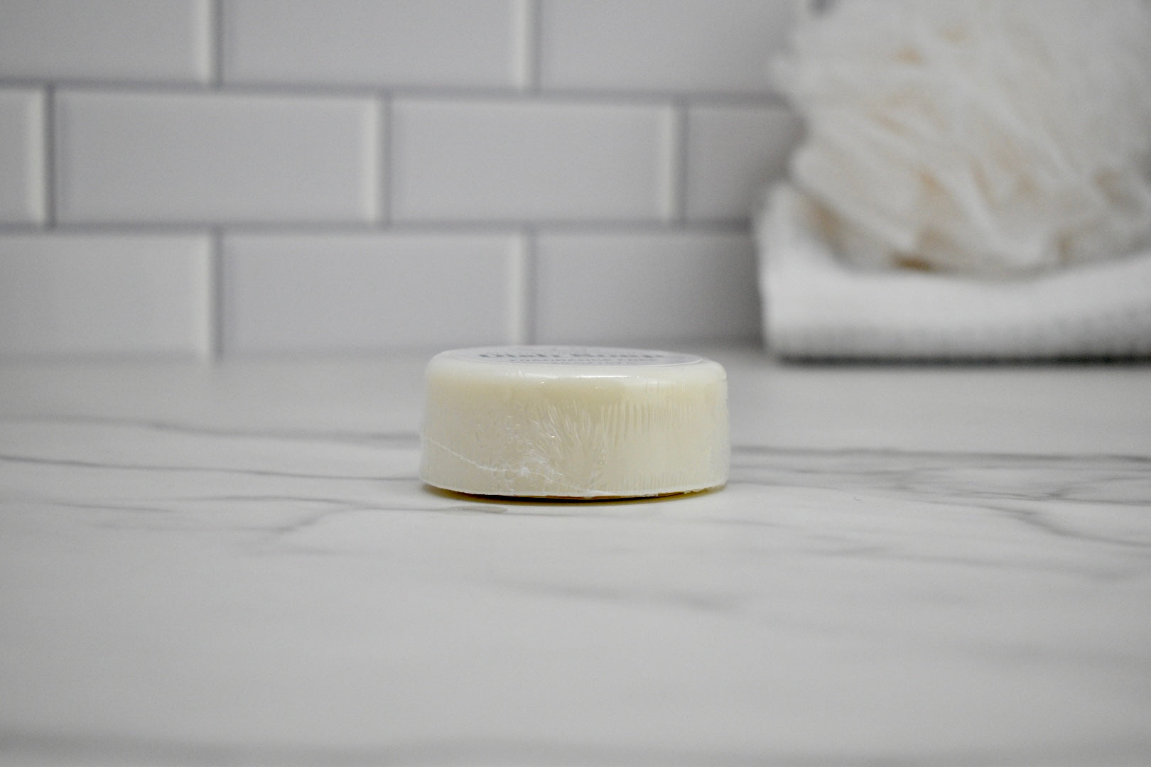 Bar of soap on a bathroom counter with tiled wall in the background