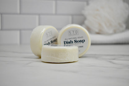 Three bars of 570 dish soap on a white surface with a blurred background