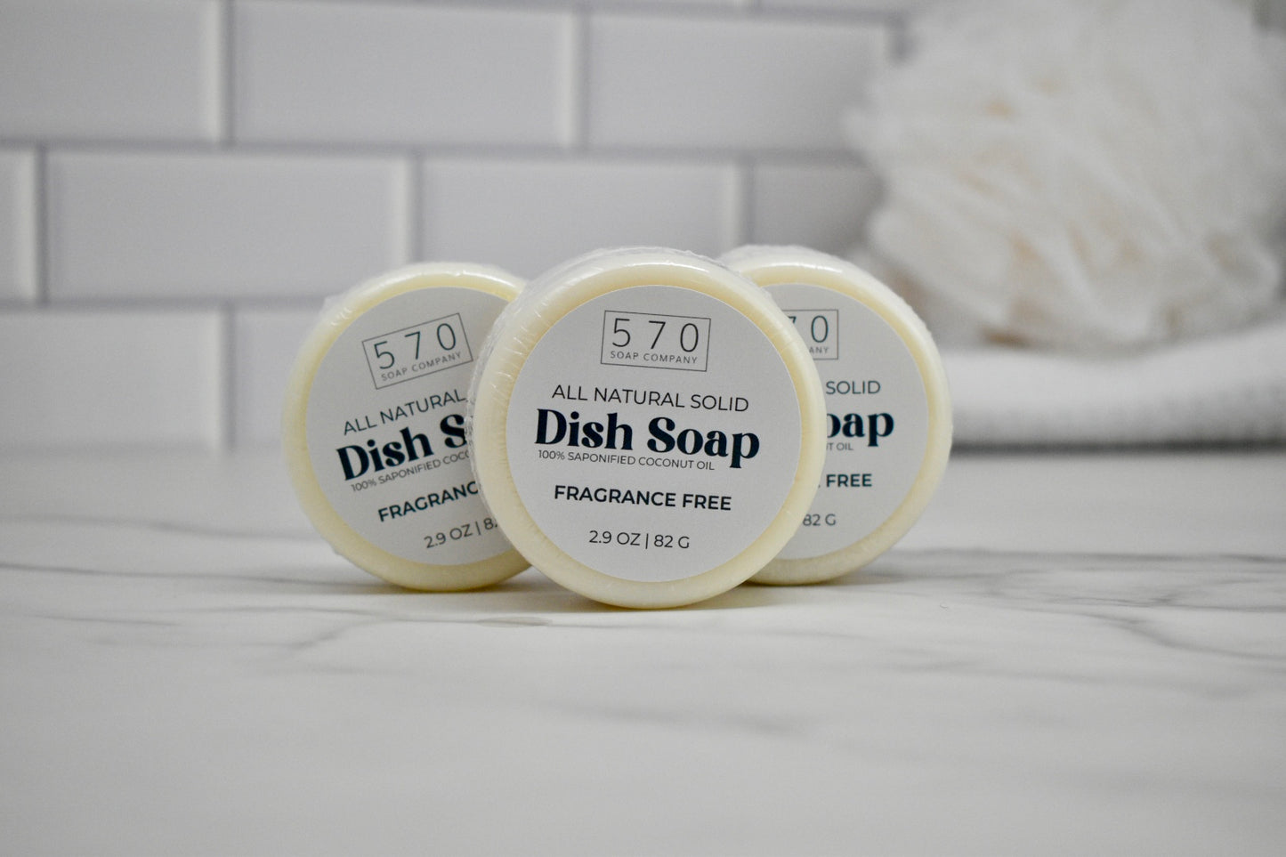 Three containers of 570 brand dish soap on a bathroom counter.