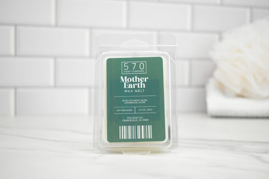 Packaged Mother Earth wax melt on a white surface with a tiled wall background