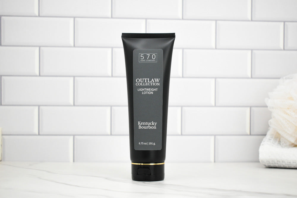 Black tube of Outlaw Collection 570 Kentucky Bourbon lighter fluid on a white tiled background