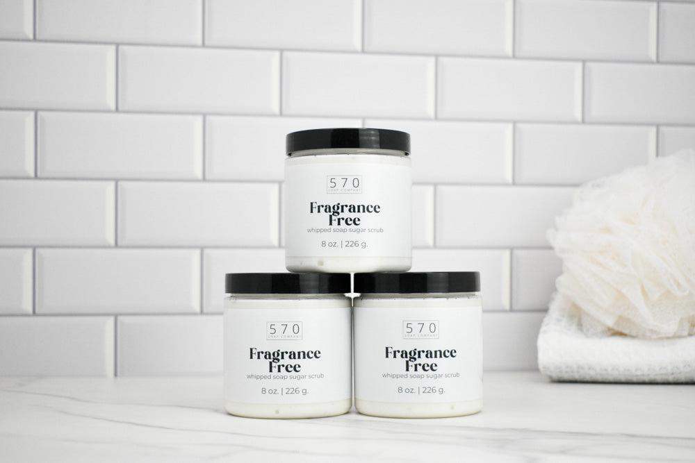 Three jars labeled '570 Fragrance Free' on a white surface with a tiled wall background.