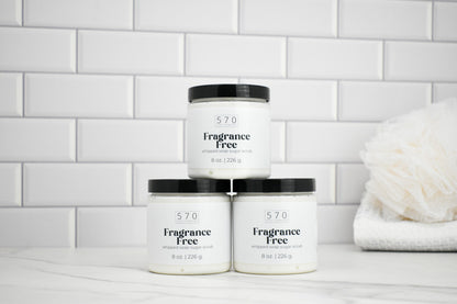 Three jars labeled '570 Fragrance Free' on a white surface with a tiled wall background.
