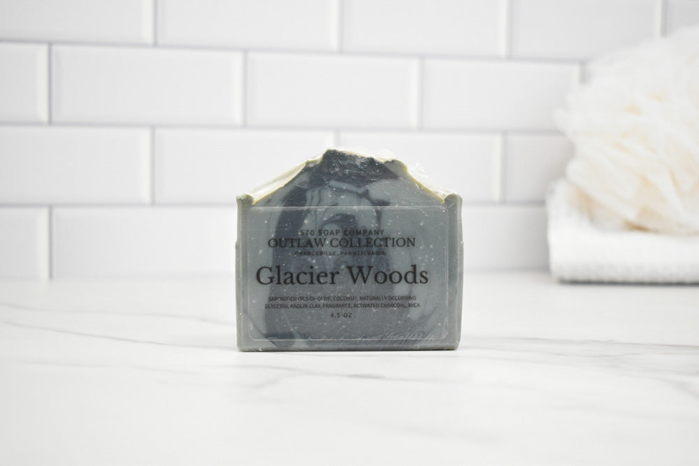 Bar of soap labeled 'Glacier Woods' on a white surface with a tiled wall background