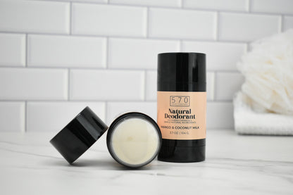 570 Natural Deodorant stick and jar on a white surface with a tiled wall background