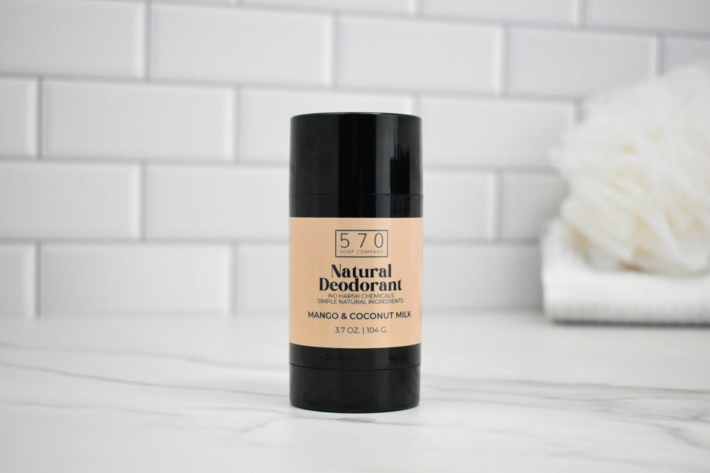 570 Natural Deodorant stick on a bathroom counter with a white tiled wall background