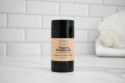 570 Natural Deodorant stick on a bathroom counter with a white tiled wall background