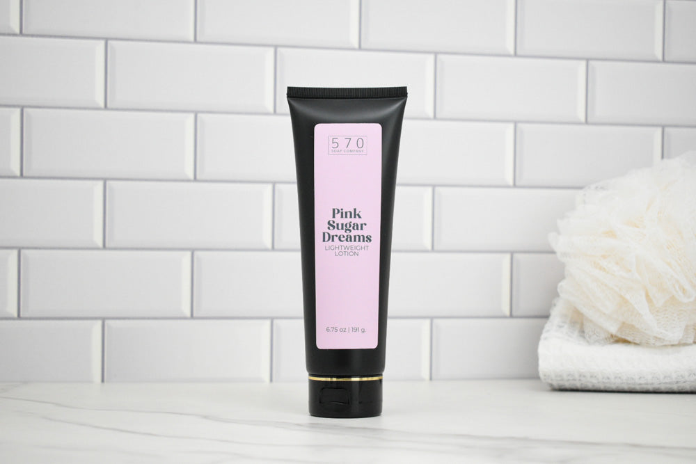 Tube of 'Pink Sugar Dreams' body lotion on a white tiled wall background