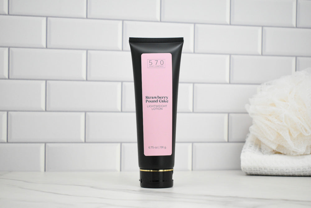 Tube of Strawberry Pound Cake Lotion on a white tiled background