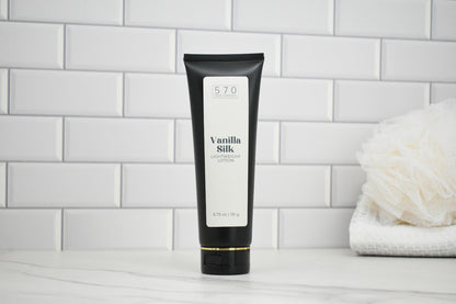 Black tube of 'Vanilla Silk' body lotion on a white tiled bathroom shelf.