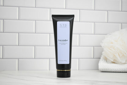 Black tube of lavender lotion on a white tiled bathroom wall background