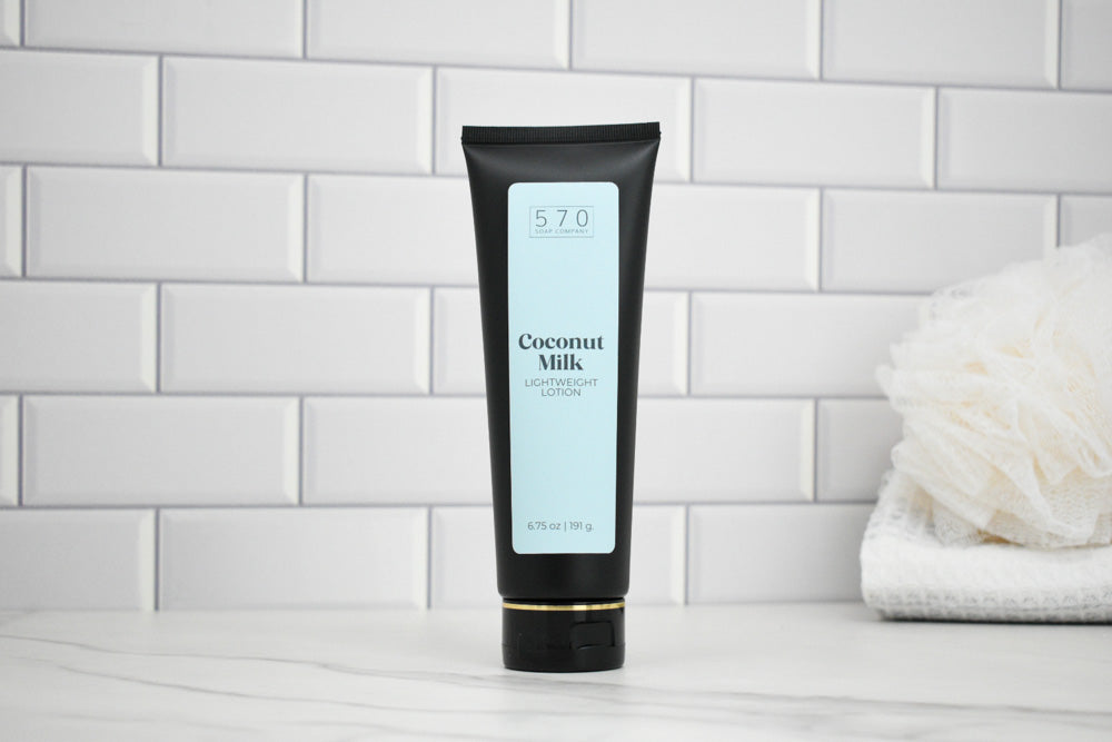 Tube of Coconut Milk lotion on a white tiled bathroom shelf