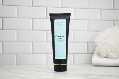 Tube of Coconut Milk lotion on a white tiled bathroom shelf