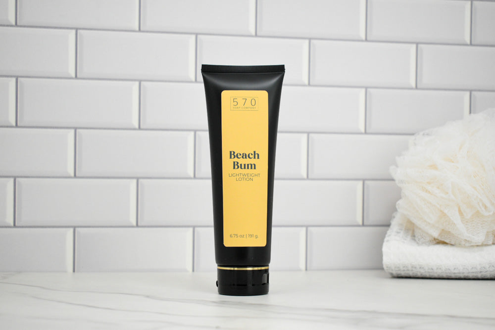 Tube of 'Beach Bum' lotion on a white surface with a tiled wall background