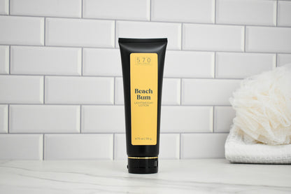 Tube of 'Beach Bum' lotion on a white surface with a tiled wall background