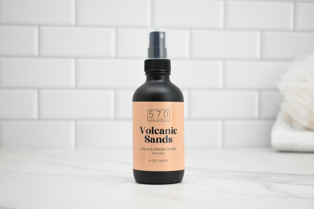 Bottle of '570 Volcanic Sands' linen and room spray on a white tiled background