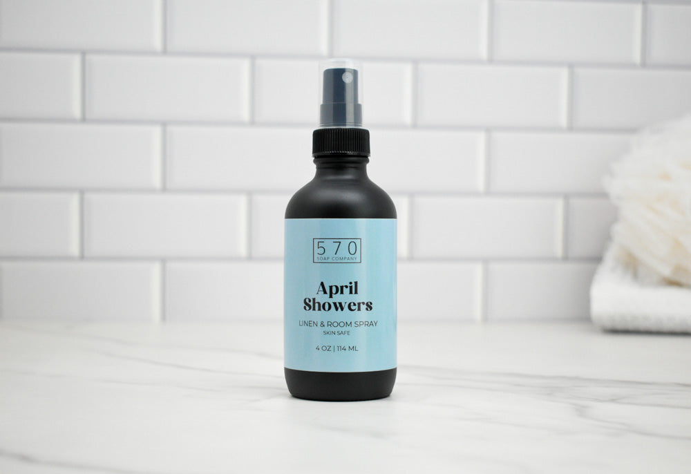 Bottle of 'April Showers' spray on a white tiled bathroom counter
