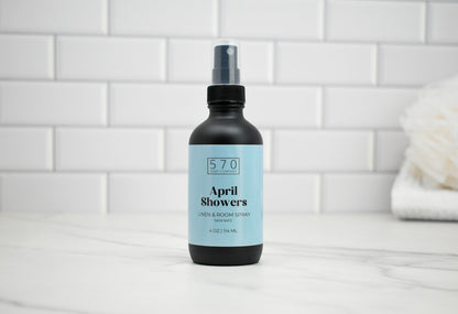 Bottle of 'April Showers' spray on a white tiled bathroom counter