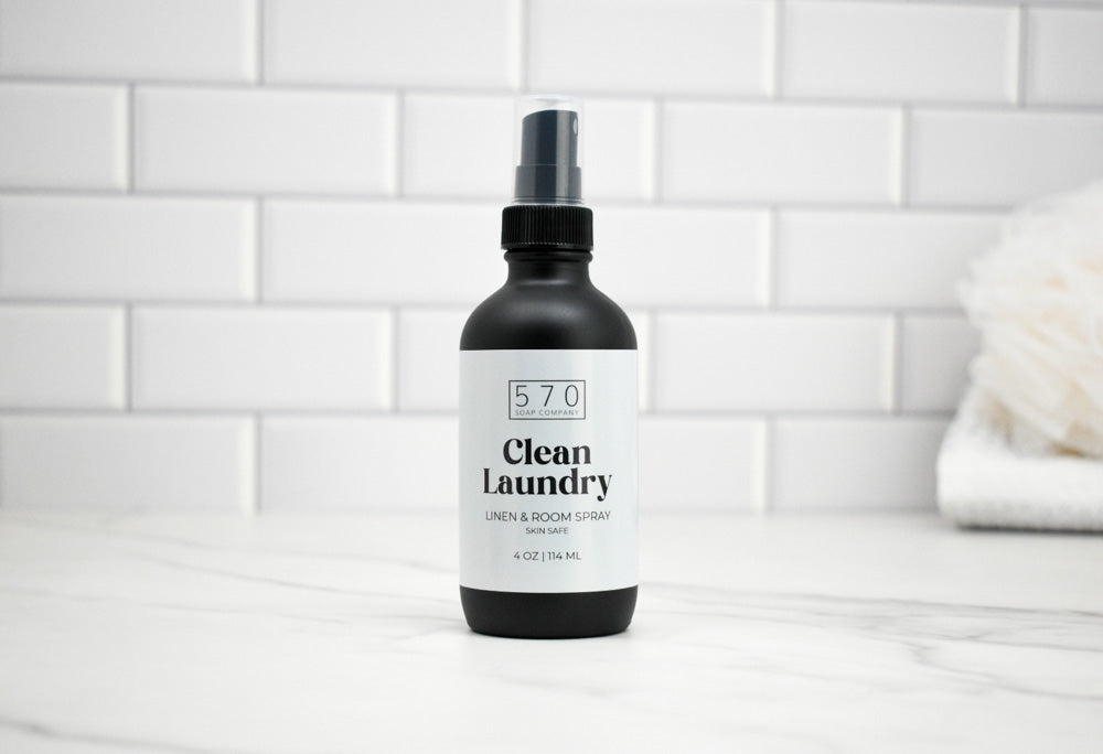 Bottle of 570 Clean Laundry spray on a white tiled bathroom floor.