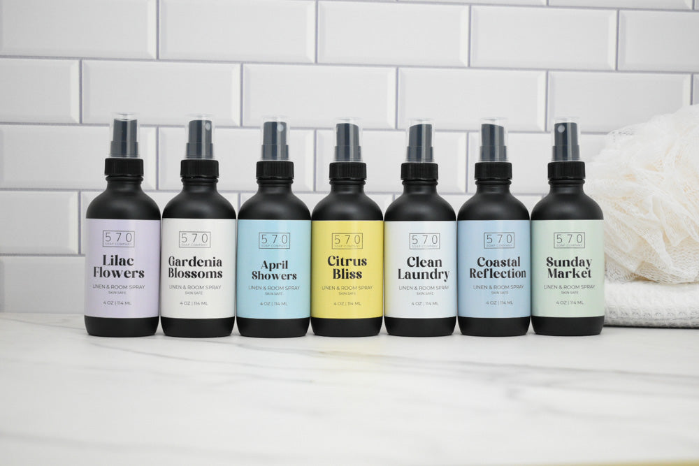 Row of 8 bottles with labels on a white surface against a tiled wall background