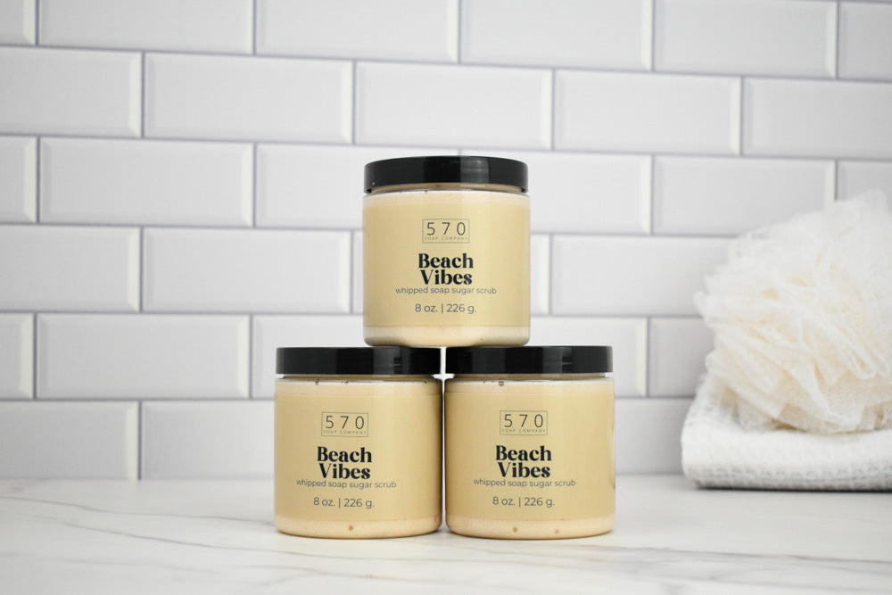 Three jars of 570 Beach Vibes product stacked on a white surface with a tiled wall background.