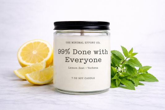 Candle jar labeled '99% Done with Everyone' with lemons and mint leaves on a white background