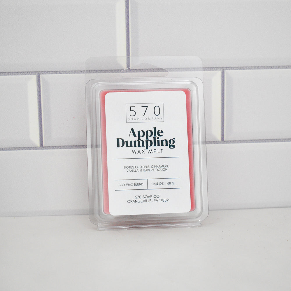 Apple Dumpling wax melt in a clear container on a tiled wall background