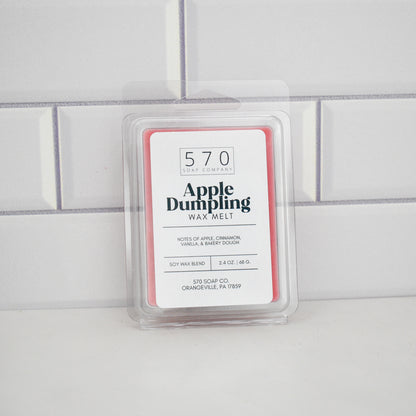 Apple Dumpling wax melt in a clear container on a tiled wall background