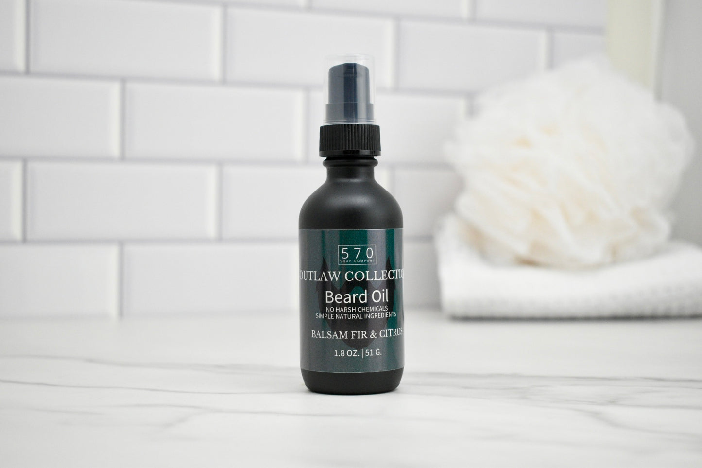Bottle of 570 Grooming Collection beard oil on a white surface with a blurred background