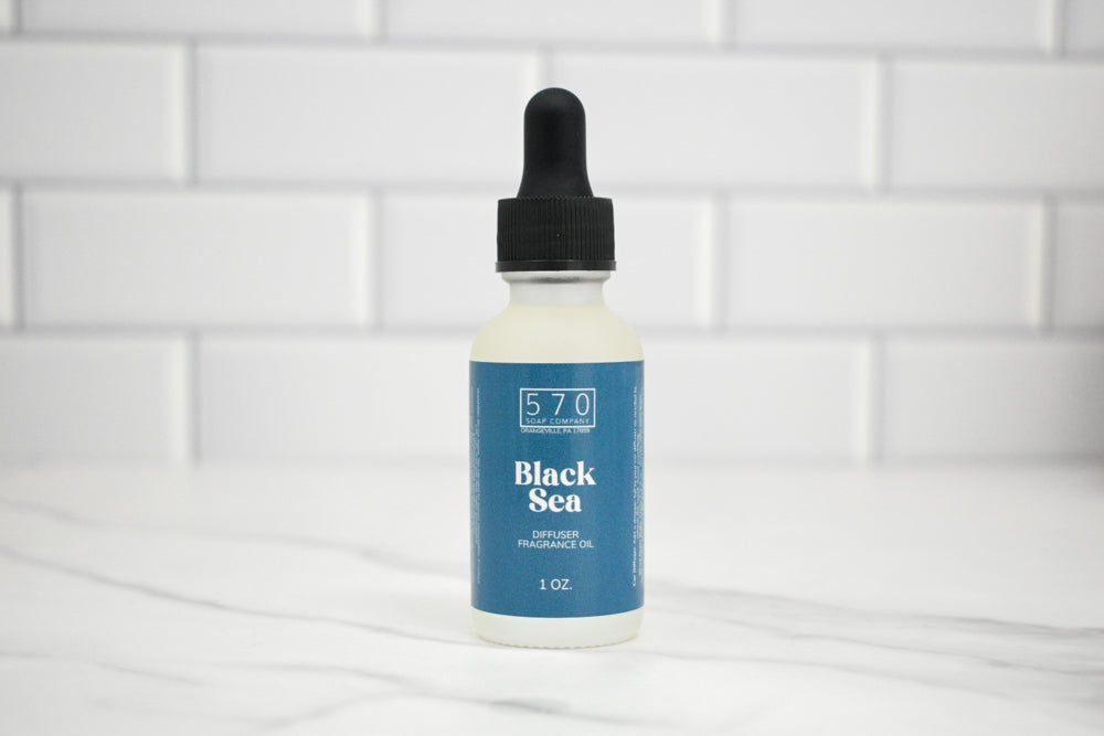 Bottle of Black Sea fragrance oil with a dropper on a white tiled background
