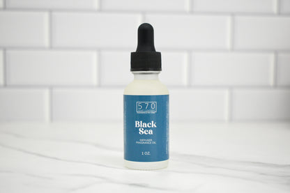 Bottle of Black Sea fragrance oil with a dropper on a white tiled background
