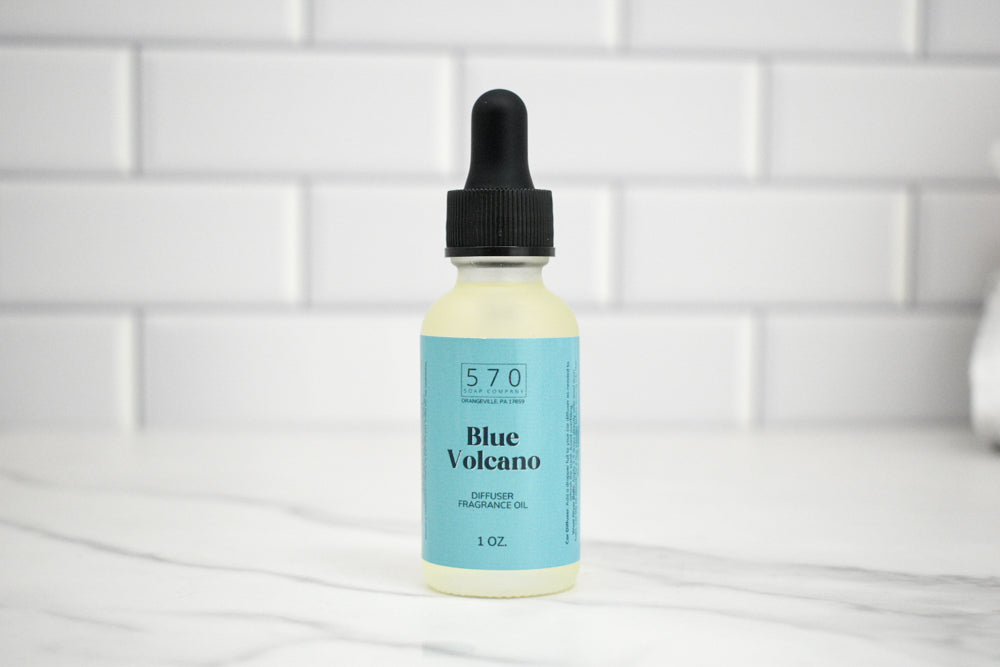 Bottle of Blue Volcano fragrance oil with a dropper on a white tiled background