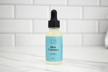 Bottle of Blue Volcano fragrance oil with a dropper on a white tiled background