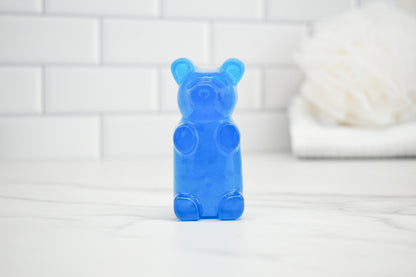 Blue gummy bear-shaped soap on a white surface with a tiled wall background