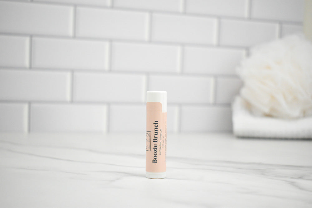 Lip balm with visible branding on a white surface and tiled wall background