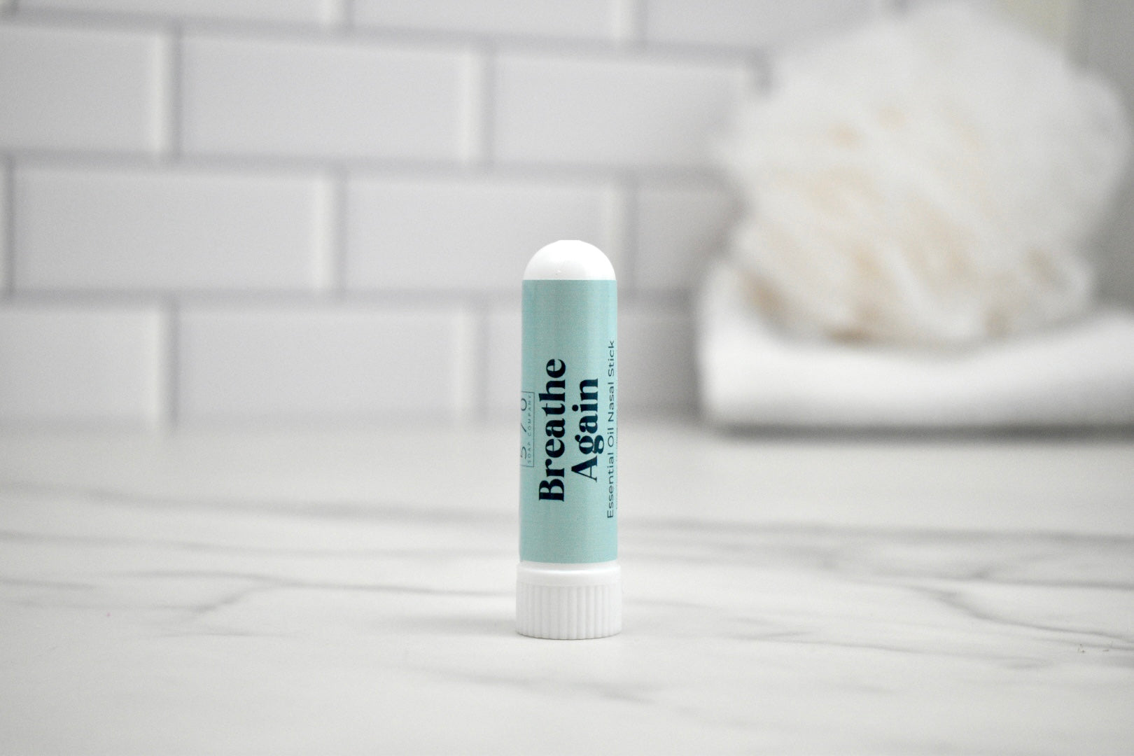 Nasal stick with 'Breathe Again' text on a bathroom counter