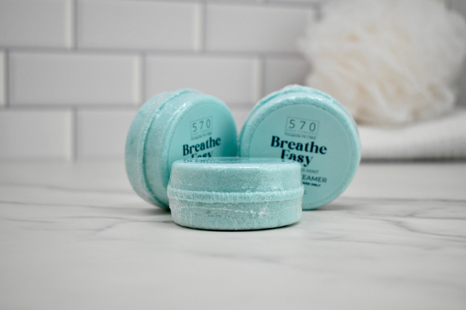 Three small containers labeled 'Breathe Easy' on a bathroom counter.