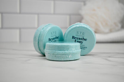 Three small containers labeled 'Breathe Easy' on a bathroom counter.
