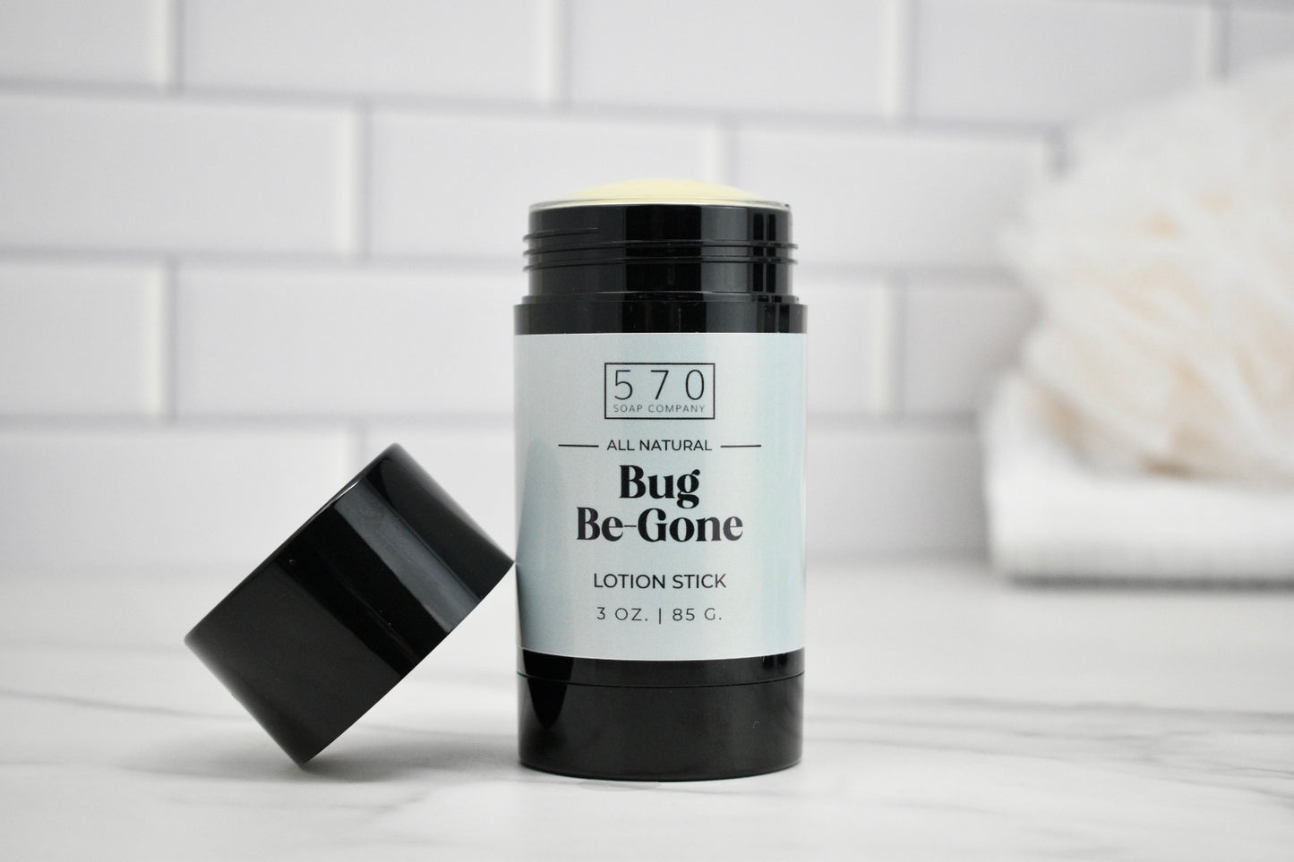 Bug Be-Gone lotion stick with black lid on a white surface