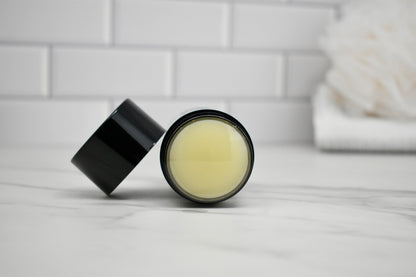 Black jar with a lid on a white surface