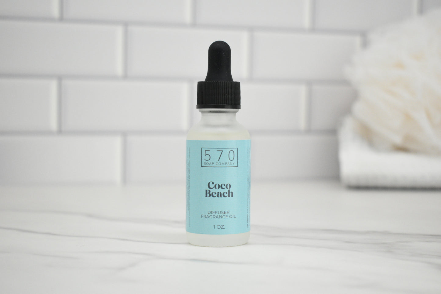 Bottle of 570 Coco Beach product on a white surface with a tiled wall background