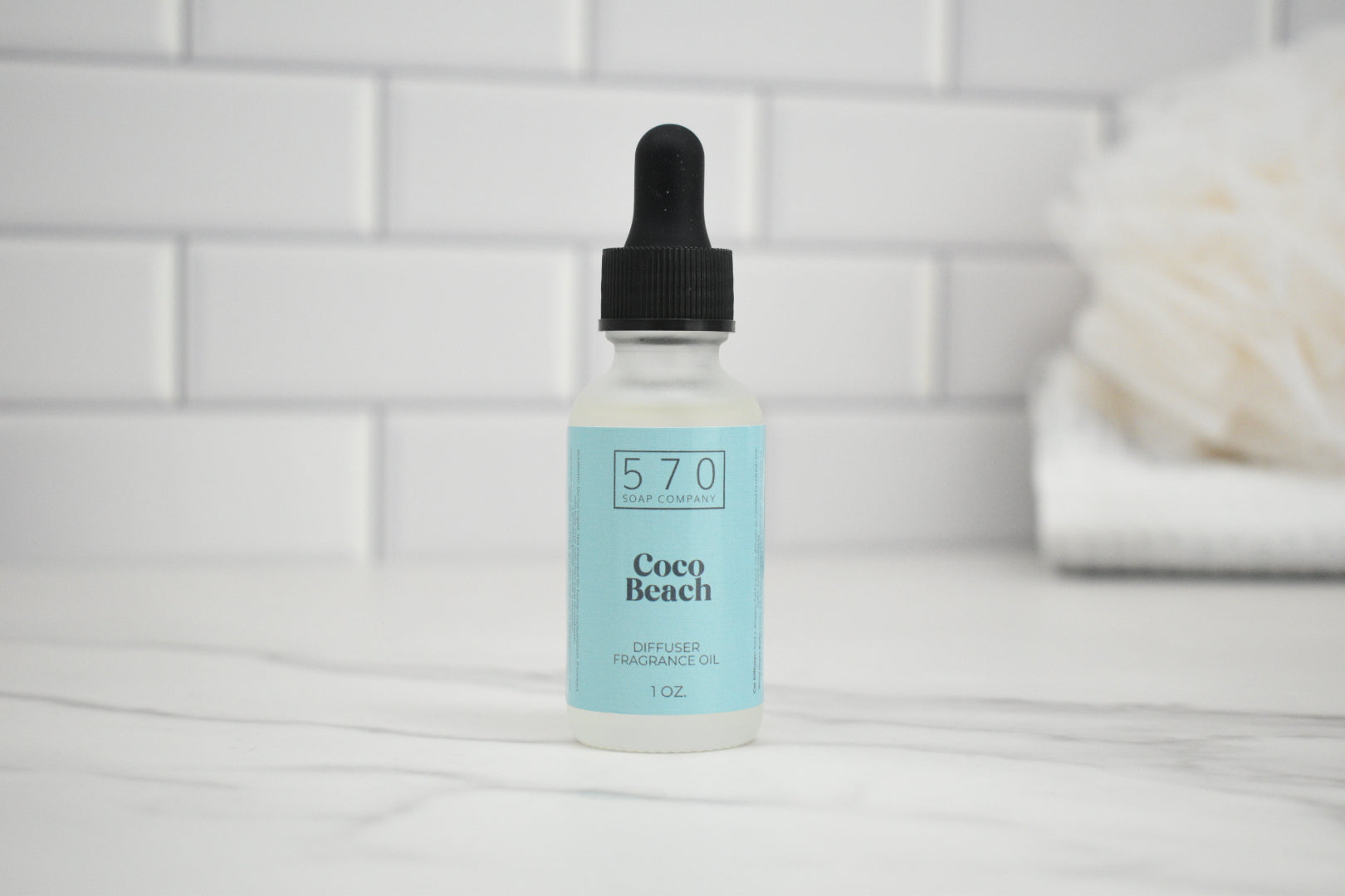 Bottle of 570 Coco Beach product on a white surface with a tiled wall background